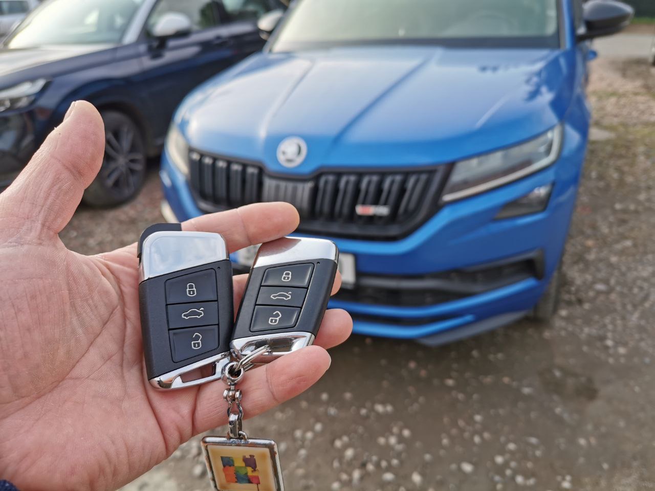 Skoda Kodiaq with keys in hand parked in a parking lot. 